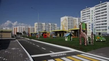 Yeşil çimlerin üzerinde renkli ekipmanlarla modern oyun parkı. İyi korunan oyun alanı çeşitli tırmanma yapılarını içerir