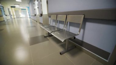 Çocuk hastanesinin oturma düzeniyle donatılmış geniş koridoru. Ziyaretçilerin rahatı için tıbbi kuruluş koridorunda metal sandalyeler.