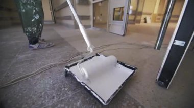 Üniformalı işçiler, beyaz boyalı ve yuvarlak silindirli oda kullanırlar. İnşaat işçisi, hastanenin tasarımını iyileştiren yenileme sürecine girdi