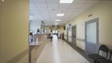 Çocuk hastanesinin tıbbi personeliyle dolu geniş koridoru. Üniformalı sağlık görevlileri ve sabah hastalarıyla dolu canlı modern bir klinik.