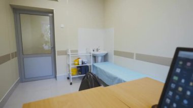 Çocuk hastanesinin tedavi odasındaki tek kullanımlık çarşaflarla kaplı tıbbi kanepe. İnceleme için mobilyaları ve cihazları olan doktor ofisi