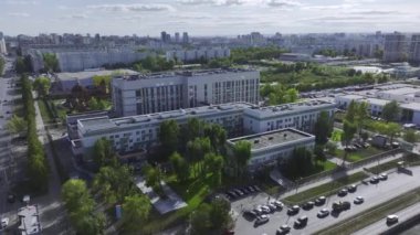 Konut alanındaki çocuklar için modern sağlık merkezi binası. Canlı trafik manzaralı yüksek katlı evler ve yol manzarası