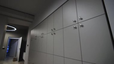 Modern spor salonundaki eşya deposu için dolapları olan bir duvar. Dikkatlice organize edilmiş alan müşterilere pratik ve güvenli seçenek sunuyor