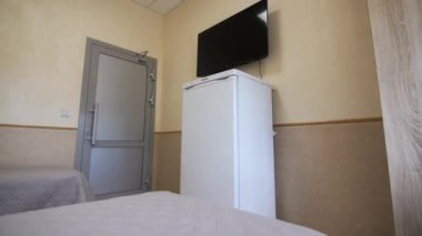 Buzdolabı ve televizyon yurt odasının girişine yakın. Öğrenciler için yatak odasında konforlu ev aletleri. Yurt konforu