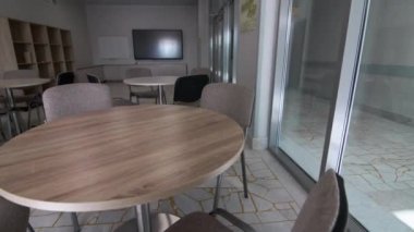Yuvarlak ahşap masaları, projeksiyon ekranı ve televizyonu olan yönetim kurulu odası. Modern mobilya ve ekipmanlarla dolu boş bir çalışma alanı. Şirket ofisi.