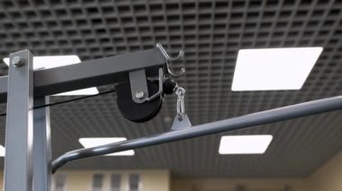 Lüks spor salonunda çelik çubuklu makara egzersiz makinesi. Omuzlar ve kol kasları sağlık kulübünde envanter çıkarıyor. Vücut geliştirme