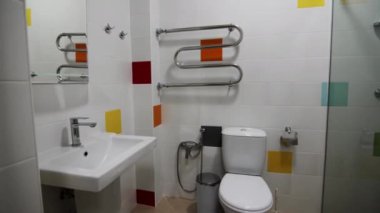 Lavabonun üzerinde klozet ve gösterişli ayna olan küçük bir banyo. Oteldeki modern malzemelerle dolu bir banyo. Kişisel hijyen bakımı