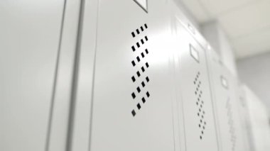 Soyunma odasının kapısında delik olan metal dolaplar. Parlak ışıklandırılmış soyunma odasında kişisel personel için hücreler. Ait olduğu depo