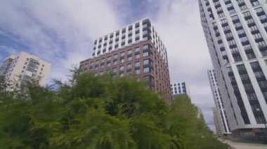 Şehir merkezinde geniş pencereli ofis binaları bulunmaktadır. İş alanı ön planda manzaralı yeşil manzaralı asfalt kaldırım manzaralı.