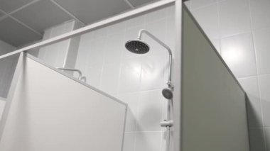 Umumi tuvaletin küçük kabininde çeşitli başlıklı duş. Modern spor kulübündeki eğitimden sonra vücut yıkama yeri. Kişisel temizlik.