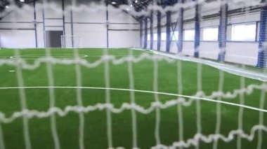 Futbol sahasının içinde futbol kalelerinin arasından görünen yapay bir saha. Aktif eğlence için profesyonel zemin. Fiziksel etkinlikler için dayanak