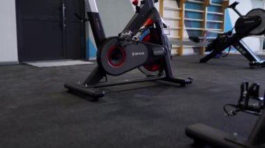 ALMATY, KAZAKHSTAN - 20 Mart 2024: Bisiklet makinesi büyük pencereli modern görünümlü iyi ışıklandırılmış spor salonunda duruyor. Maksimum verimlilik için tasarlanmış yüksek kaliteli çalışma ekipmanları