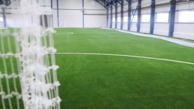 Yoğun çimenlik ve futbol golleriyle donatılmış uzun spor sahasının içi. Geçici yapıların demir kiriş sistemiyle güçlendirilmesi