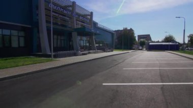 Modern stilin spor kompleksi bisiklet stantları ve otoparklar da dahil. Açık yaz gününde güneş ışığının tadını çıkaran fütüristik bina
