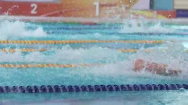 ALMATY, KAZAKHSTAN - 19 AĞUSTOS 2024: Yüzücüler kelebek vuruşu olarak gücünü gösteriyor. Yüzücülerin elleri ve bacakları hızlarını korumak için mükemmel bir senkronizasyon içinde hareket eder.