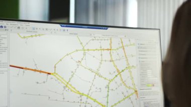 Enstitü 'nün kadın çalışanı geniş ekranda bölgenin topografik haritasını görüyor. Uzman, geliştirme ve kentleşme alanlarını analiz ediyor