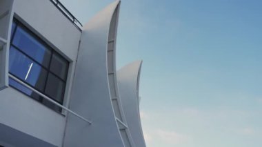 Enstitü parlak kış güneşiyle parıldıyor. Yüzeyde yumuşak gölgeler oynuyor. Pencere açıklık hissi ekleyerek aydınlık günü yansıtır