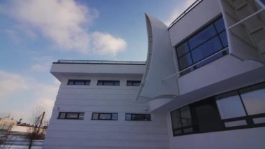 Ön cephenin bir kısmı parlak kış ışığını yakalıyor ve yüzeyi karla zıt düşüyor. Pencere soğuk, berrak gökyüzünü yansıtır. Huzuru arttırır.