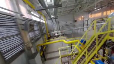 Yüksek tavanlı ve endüstriyel boru hatlarıyla dolu fabrika atölyesi. Karton ambalajlar üreten fabrika yedek tesisler
