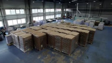 Kağıt ve karton fabrikası, istiflenmiş kutularla dolu bir depo. İlgili şirketlere daha fazla teslimat için büyük paketler katta duruyor.