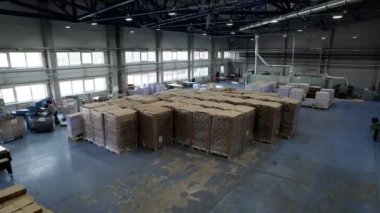Büyük bir depo dolusu kağıt ve makineli karton fabrikası. Depo araçları ve ürünleri kartonla çalışmak için paketlerde saklar