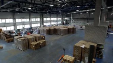 Geniş bir depo dolusu büyük kutuları olan kağıt ve karton fabrikası. Depo, daha fazla ulaşım için hamur ve kağıt endüstrisi ürünleri depoluyor.