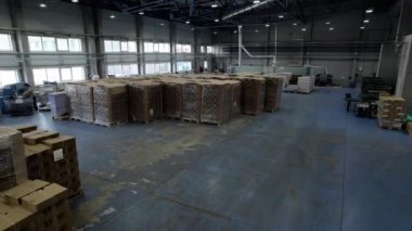 Konteynır ve mukavvadan yapılmış malzemeler için depo. Depo çalışanları daha fazla dağıtım için malzeme oluşturma üzerinde çalışırlar.