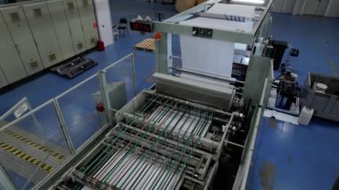 İşlem makinesi karton ambalaj atölyesinde çalışır. Makine kartonla çalışmak için ekipman ve mekanizmaların yanında çalışır