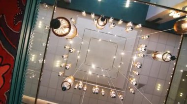 Parlak doğu tarzı kolye lambaları tavandan sarkıyor. Uzun ışıklar, klasik Tatar desenleri ve sembolleriyle süslenmiş odayı aydınlatıyor.