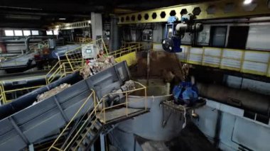 ALMATY, KAZAKHSTAN - 24 Eylül 2024: Makine karton paketleme için hammadde işliyor. Endüstriyel ekipmanlar, karton imalatı için posa üreten tankta eski kağıtları kaynatıyor.