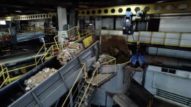 ALMATY, KAZAKHSTAN - 24 Eylül 2024: Çöpe atılmış kağıt akışı balyaları geri dönüşüm cihazına. Endüstriyel makine kağıt malzemelerini geri dönüştürüyor. Çok katmanlı karton üretiyor.