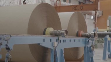 ALMATY, KAZAKHSTAN - 24 Eylül 2024: Yuvarlanma makinesine yüklenmiş kağıt makarası. Karton kaplama için kağıt yapma süreci. Sanayi amaçları için kağıt üretimi