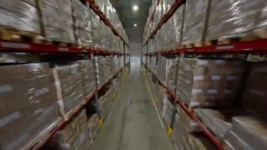 ALMATY, KAZAKHSTAN - 24 Eylül 2024: Kağıt paketleri üretim fabrikası FPV 'de yüksek raflara istiflenmiş. Kağıt imalatı endüstriyel tesisi. Ürünler ve makinelerle iç mekan.