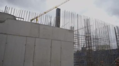 ALMATY, KAZAKHSTAN - Haziran 04 2024: Metal takviyesi çerçevesinde beton sütun parçası monte edildi. Beton zeminin oluşumu. Kasvetli gökyüzüne karşı sanayi manzarası