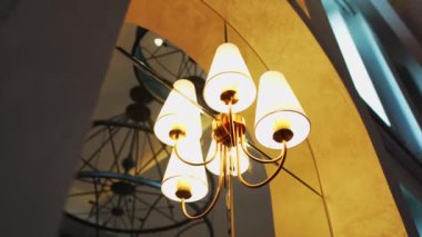 Modern avize büyük salon aydınlatma alanında asılı. Cam, ışıkları ve yuvarlak şekilli büyük dekoratif feneri yansıtır.