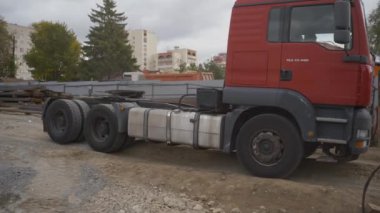 ALMATY, KAZAKHSTAN - 4 Haziran 2024: Kamyon römorku inşaat alanının kumlu yolunda yavaşça geri geri geri geri gidiyor. Ağır enkaz ve inşaat malzemelerini taşımak için kamyonlar