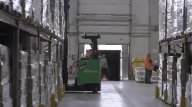 ALMATY, KAZAKHSTAN - 08 Ekim 2024: Forklift nakliyesi ambar rafları arasında tamamlanmış ürünler. Bina, ambalaj şeklinde büyük malzeme stokları içeriyor