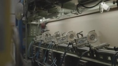 Cihazların yanına yerleştirilmiş karton kaplama üzerinde çalışan makineler. Oda, kutuların ve bükülmüş kartonların üretimi için ham madde üretiyor.