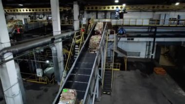 Taşıma bandı atık kağıt balyalarını işlemek için tanka taşıyor. Kutu biçimindeki ham madde işleme hazırlık aşamasından geçer