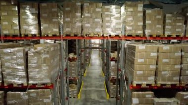 Karton fabrika deposunda kutularla dolu raflar. Depo, özel araçlara yüklenmek için tamamlanmış materyaller içeriyor