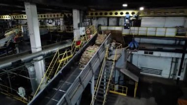 Basınçlı kağıt balyaları daha ileri işlemler için tanka düşer. Ham madde, büyük fabrika atölyesinde taşıyıcı bant boyunca yavaşça hareket eder.