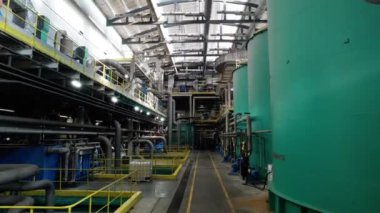Teçhizatlı karton fabrikasının üretim atölyesi. Geniş bir önerme, bitki bölümleri etrafında su taşımak için büyük tanklar içerir.