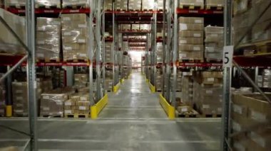 Raflarda bitmiş ürünlerle dolu karton fabrika koridoru. Uzun yapılar, kutular halinde malzemelerin kompakt depolanmasını sağlar