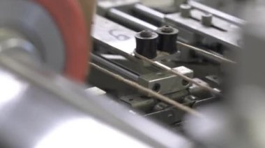 Özel makine kıvrımlı kartondan dalgalı bir şekil yaratıyor. Etkin silindirleri ve iplikleri olan endüstriyel ekipmanlar bitmiş materyal oluşturur