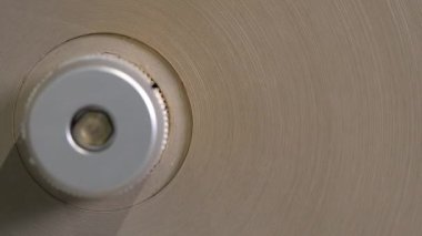 Karton silindirik mekanizmada yavaşça hareket eder. Makine malzeme yüzeyini işliyor. Dükkanda gerekli olan ürünü veriyor.