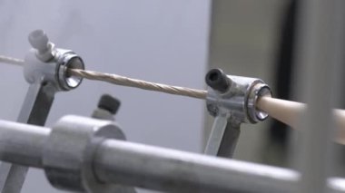 Küçük silindirler, hareket eden karton malzeme şeklini alırlar. Karton fabrikası atölyesi son ürün olarak ince ip üretmek için makine içerir