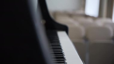 Görsel ritme uyan siyah beyaz piyano tuşları. Pencereden gelen hafif ışık, müzik severlerin hayranlığını çeken yüzeyi vurguluyor