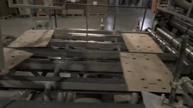 Taşıyıcı üretim hattı boyunca ince karton kağıtlar taşıyor. Özel ekipman, levha işleminin bir sonraki aşamasına malzeme teslimatını hızlandırır