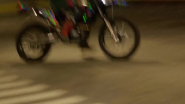 ALMATY, KAZAKHSTAN - 29 AĞUSTOS 2024: Profesyonel motosiklet yarışçısı otoparkta daireler çiziyor. Üniformalı adam güvenli bir şekilde spor aracı kontrol ediyor.