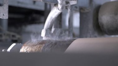 Özel geniş silindirik nesneler karton ağı işler. Kurutma makinesi nemi emerek ince yüzeyi sertleştirir.